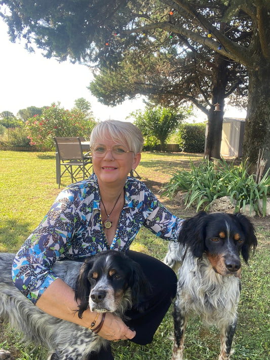 Marie-Pierre Garcia, fondatrice de Synerlia, avec deux chiens dans un jardin